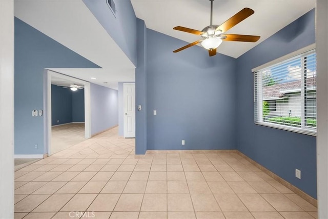 spare room with visible vents, a ceiling fan, baseboards, light tile patterned floors, and lofted ceiling