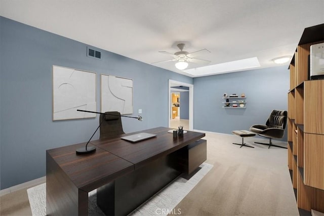 office area featuring baseboards, a ceiling fan, visible vents, and light carpet