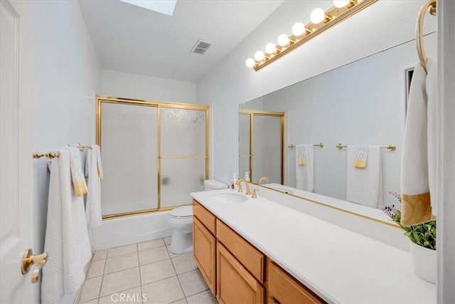 bathroom with vanity, visible vents, shower / bath combination with glass door, tile patterned floors, and toilet