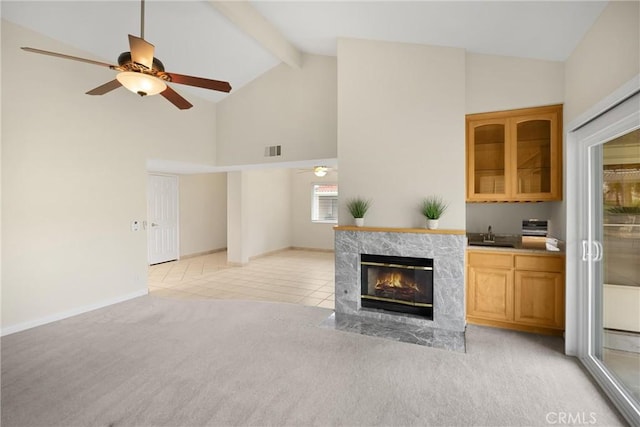 living room with visible vents, a ceiling fan, high vaulted ceiling, and light colored carpet