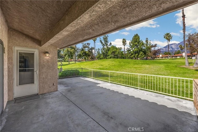view of patio with fence and a mountain view