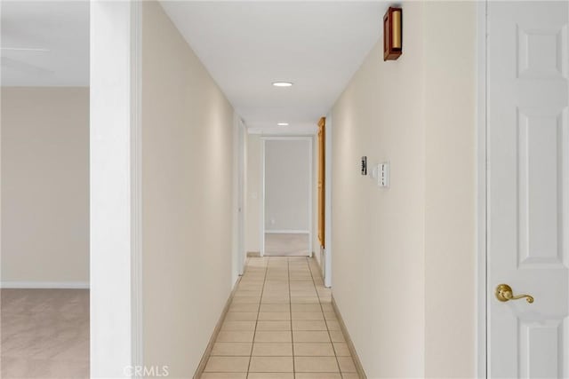 corridor with baseboards and light tile patterned flooring