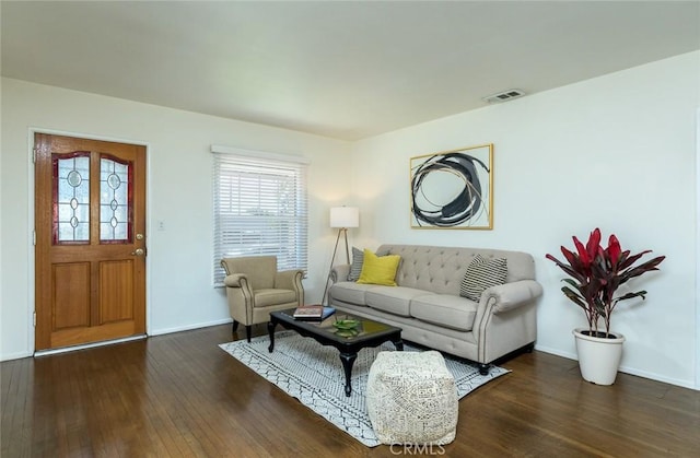 living room with visible vents, baseboards, and hardwood / wood-style floors