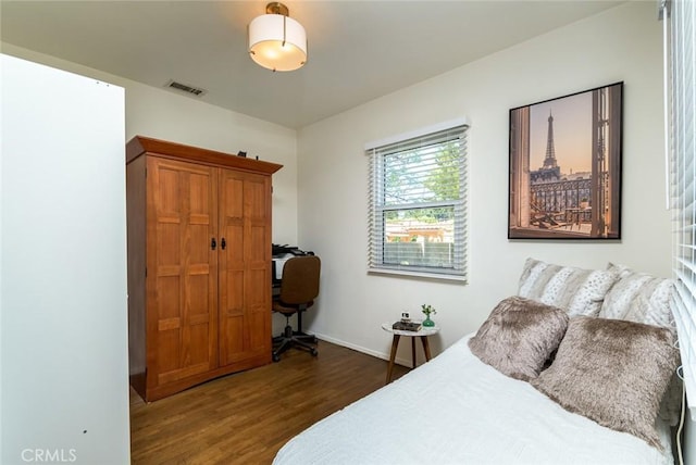 bedroom featuring wood finished floors, visible vents, and baseboards