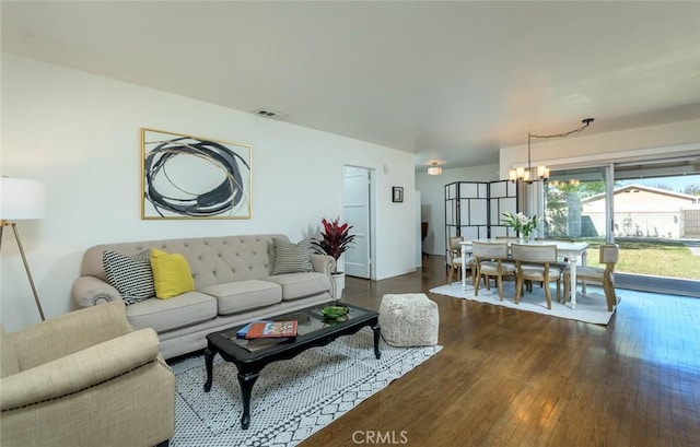 living room with a notable chandelier, dark wood-type flooring, and visible vents