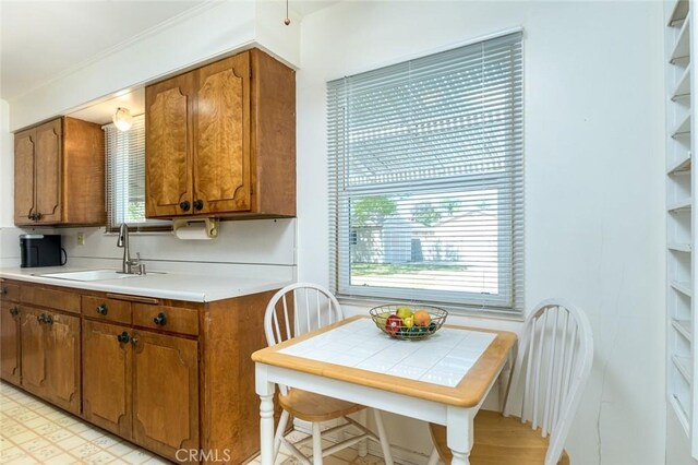 kitchen with a sink, brown cabinets, and light countertops