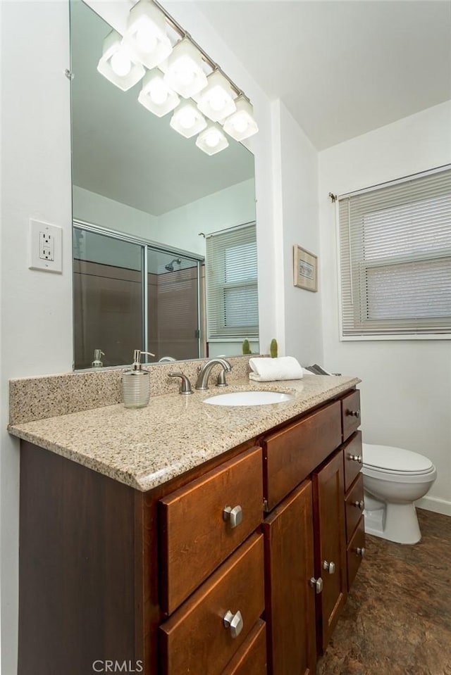 full bath with vanity, toilet, and a shower with shower door