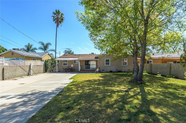 view of front of home with stucco siding, driveway, a front lawn, and fence