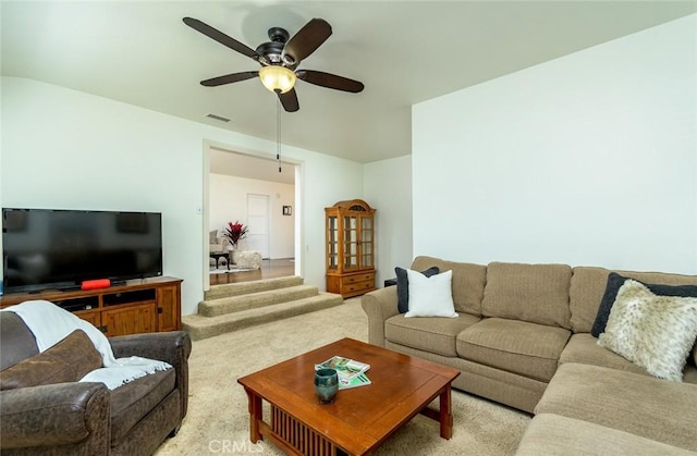 living room featuring light colored carpet, visible vents, and ceiling fan