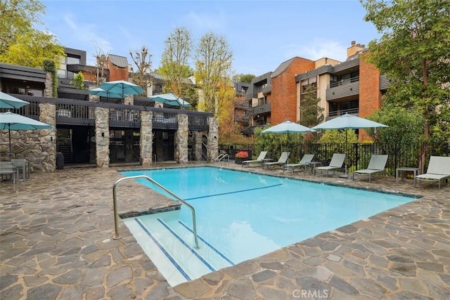 pool featuring fence and a patio area