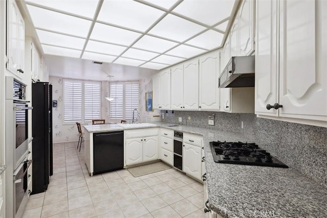 kitchen featuring a peninsula, a sink, black appliances, white cabinets, and extractor fan