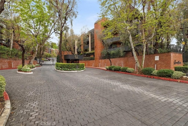 view of road featuring curbs, a gated entry, and a gate