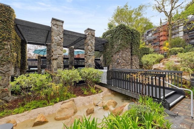 view of home's community with a pergola and fence