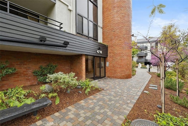 exterior space with stucco siding, a patio, and brick siding