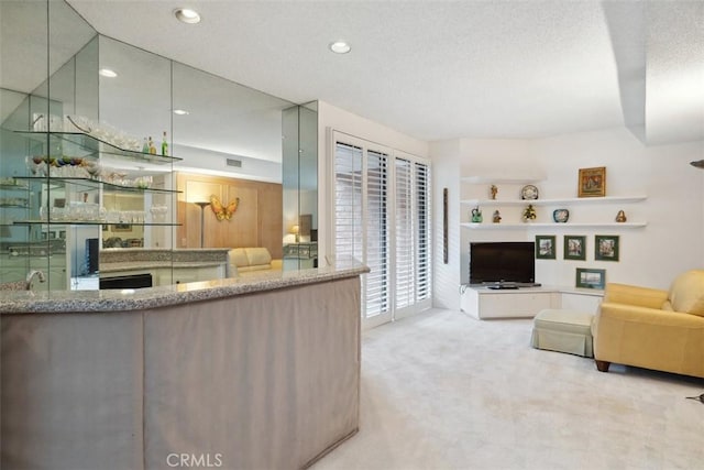 living room featuring wet bar, recessed lighting, carpet floors, and a textured ceiling