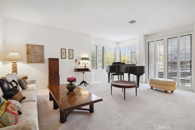 living room featuring visible vents, carpet floors, and a textured ceiling