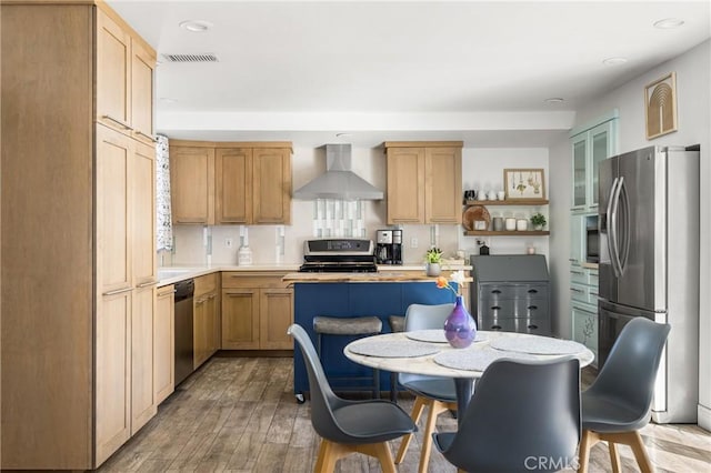 kitchen with visible vents, appliances with stainless steel finishes, light countertops, and wall chimney range hood