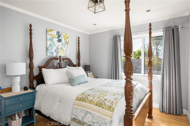 bedroom with baseboards, crown molding, and light wood-style floors