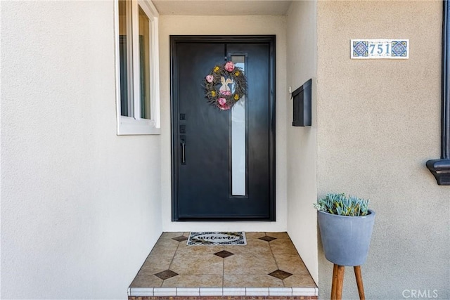 property entrance with stucco siding