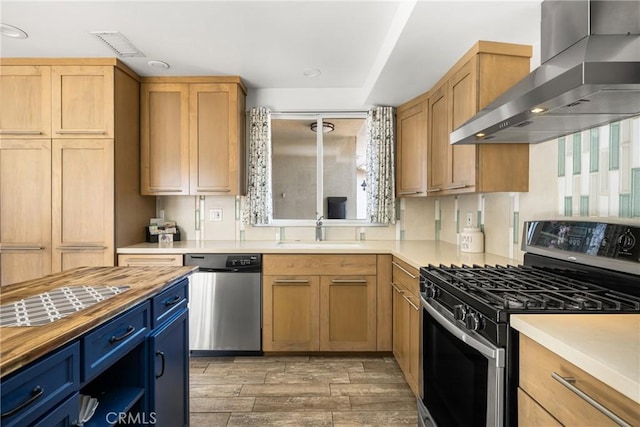 kitchen with butcher block countertops, light wood-style flooring, a sink, stainless steel appliances, and wall chimney exhaust hood