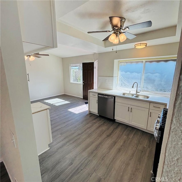 kitchen featuring range with gas cooktop, a sink, dark wood-type flooring, dishwasher, and a raised ceiling