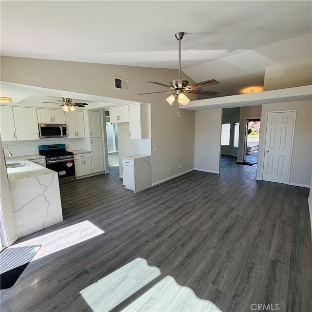 unfurnished living room featuring vaulted ceiling, a ceiling fan, visible vents, and dark wood-style flooring