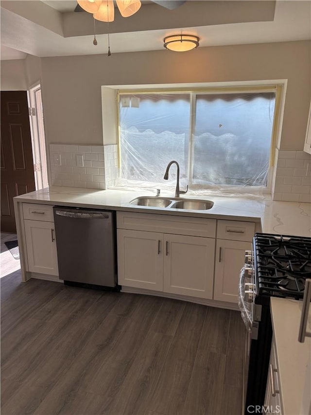 kitchen featuring dark wood-type flooring, a sink, white cabinetry, stainless steel appliances, and light countertops