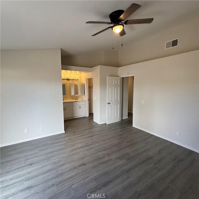 unfurnished living room with visible vents, baseboards, ceiling fan, dark wood finished floors, and a sink