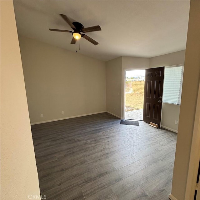 spare room with ceiling fan, baseboards, and dark wood finished floors