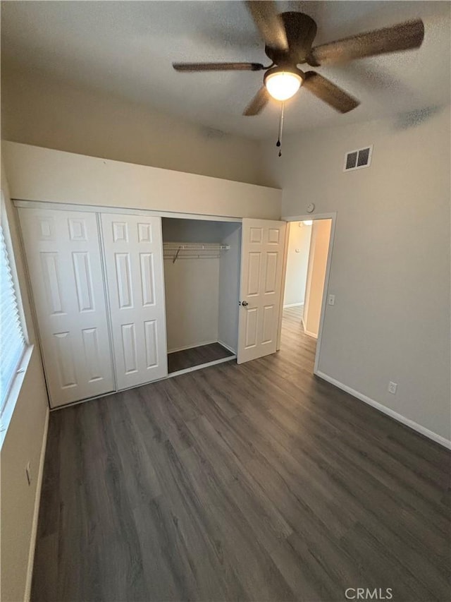 unfurnished bedroom with visible vents, a ceiling fan, a closet, baseboards, and dark wood-style flooring