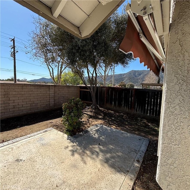 view of yard with a mountain view, a patio, and a fenced backyard