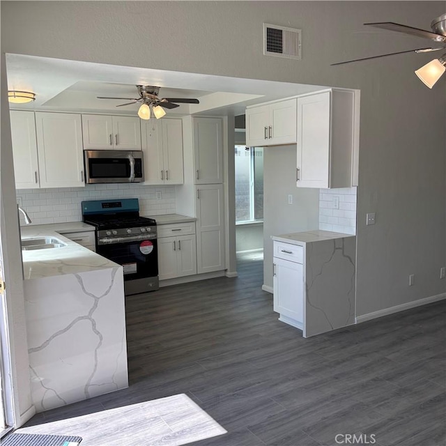 kitchen with visible vents, a sink, ceiling fan, white cabinets, and appliances with stainless steel finishes