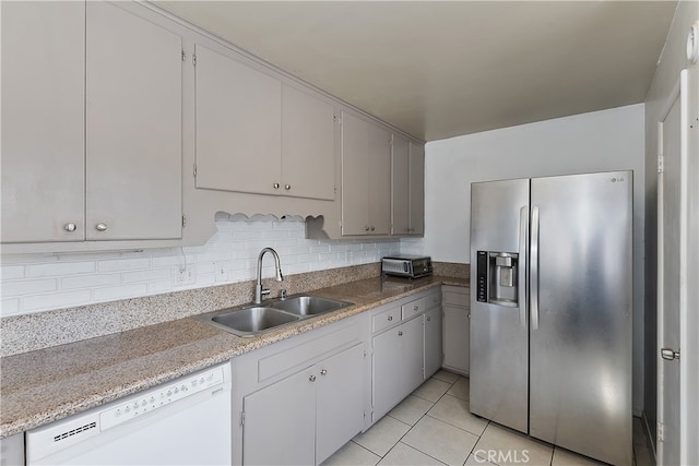 kitchen with tasteful backsplash, stainless steel fridge with ice dispenser, dishwasher, light tile patterned floors, and a sink