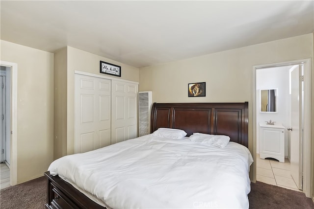 carpeted bedroom with tile patterned floors and a closet