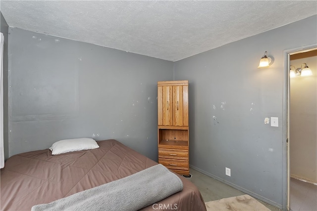 bedroom featuring baseboards and a textured ceiling