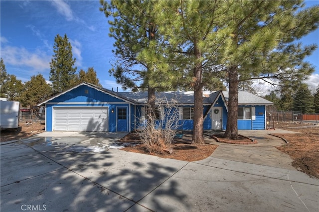 single story home with concrete driveway, an attached garage, and fence