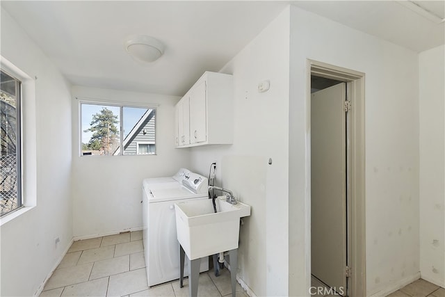 laundry room featuring light tile patterned floors, washing machine and dryer, cabinet space, and baseboards