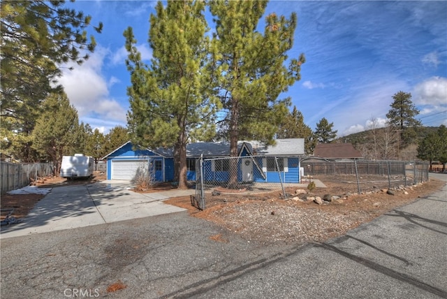 ranch-style home featuring driveway, an attached garage, and fence