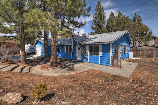 view of front of home featuring a garage and fence