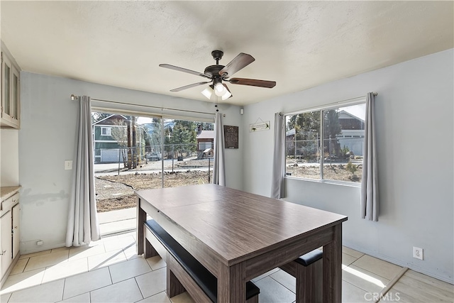 dining area featuring light tile patterned floors, plenty of natural light, and a ceiling fan