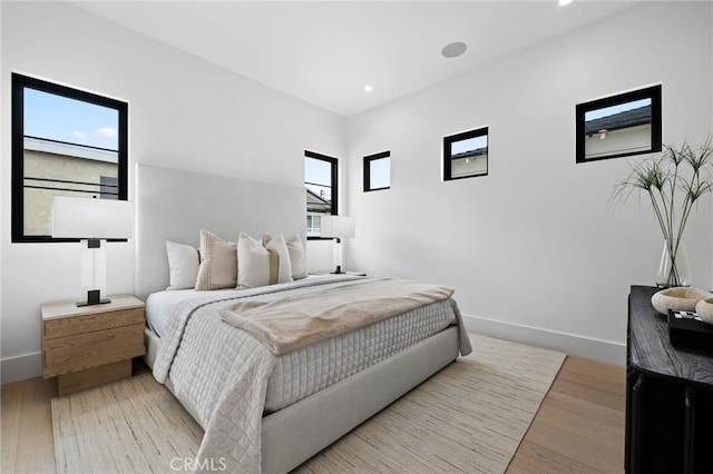 bedroom with recessed lighting, wood finished floors, and baseboards