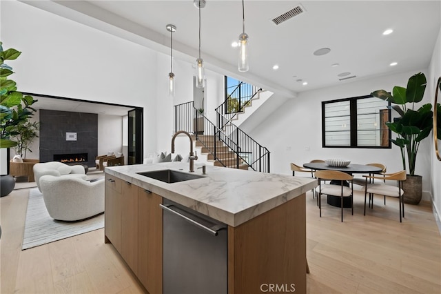 kitchen featuring visible vents, a sink, dishwasher, modern cabinets, and open floor plan