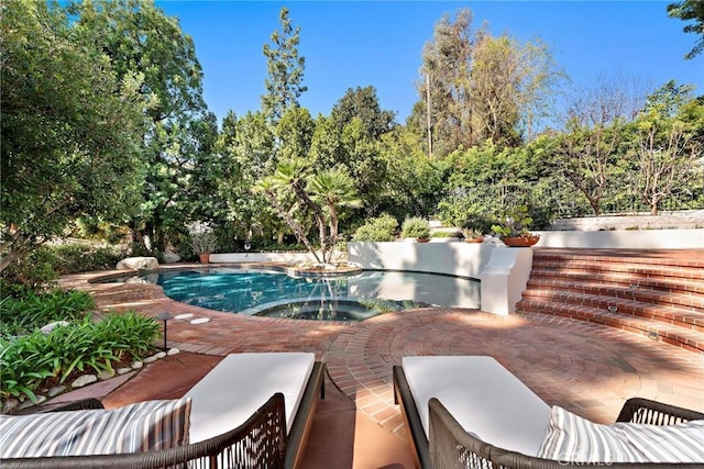 pool featuring a patio and an in ground hot tub