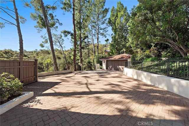 view of patio featuring an outdoor structure and fence