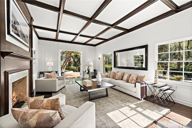 living room with a premium fireplace, coffered ceiling, and wood finished floors