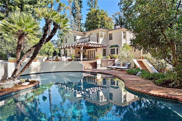 outdoor pool with a patio area and stairs