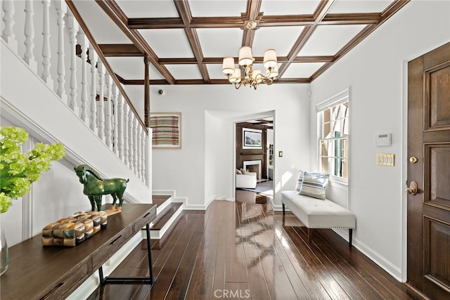 foyer featuring a notable chandelier, coffered ceiling, dark wood-style floors, baseboards, and stairs