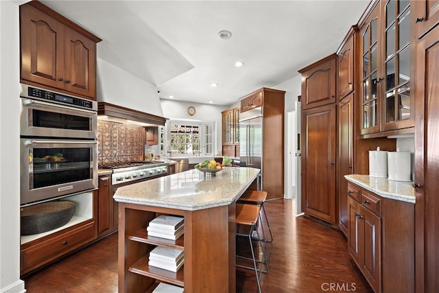 kitchen featuring open shelves, stainless steel appliances, light stone counters, and a kitchen island