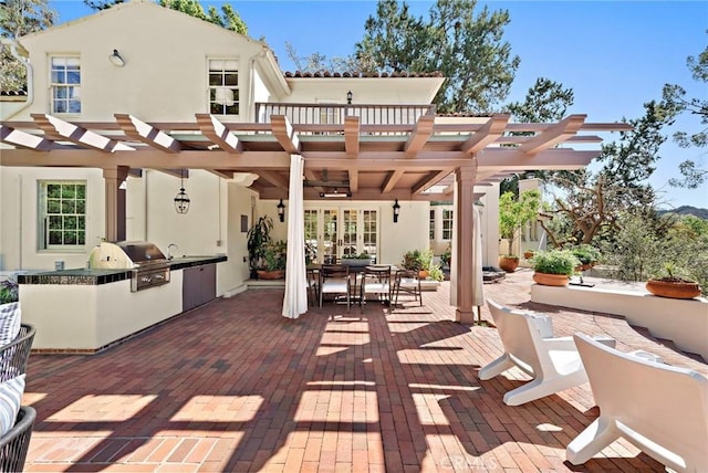 view of patio with outdoor dining space, exterior kitchen, a pergola, and grilling area