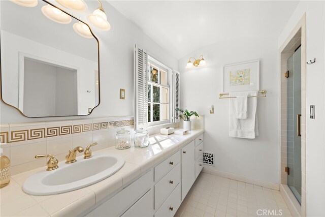 full bathroom featuring visible vents, a shower stall, tile patterned flooring, baseboards, and vanity